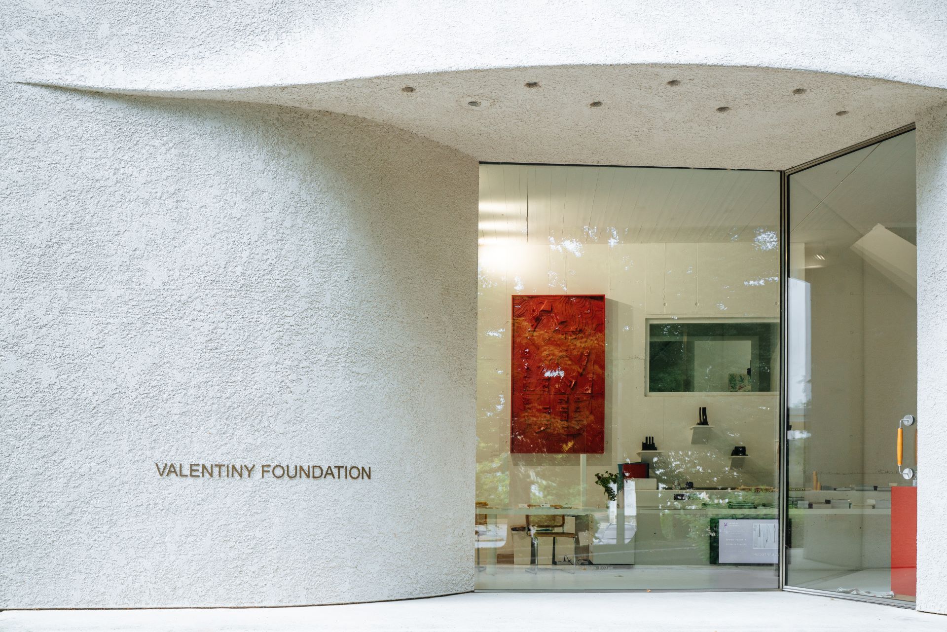 Le bâtiment de la Valentiny Foundation est photographié depuis l'entrée principale. Le bâtiment est blanc et structuré.