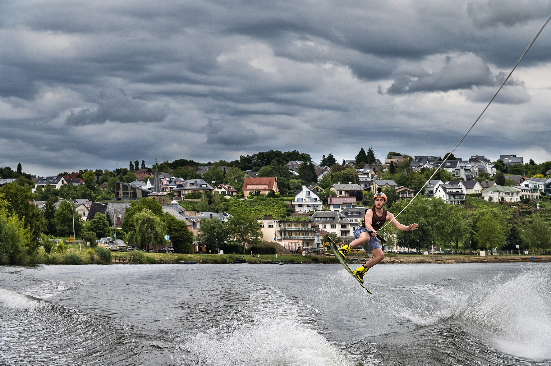 Glenn Birsens, un wakeboarder, se laisse tirer sur la rivière par un bateau à moteur à environ 35 kilomètres par heure.