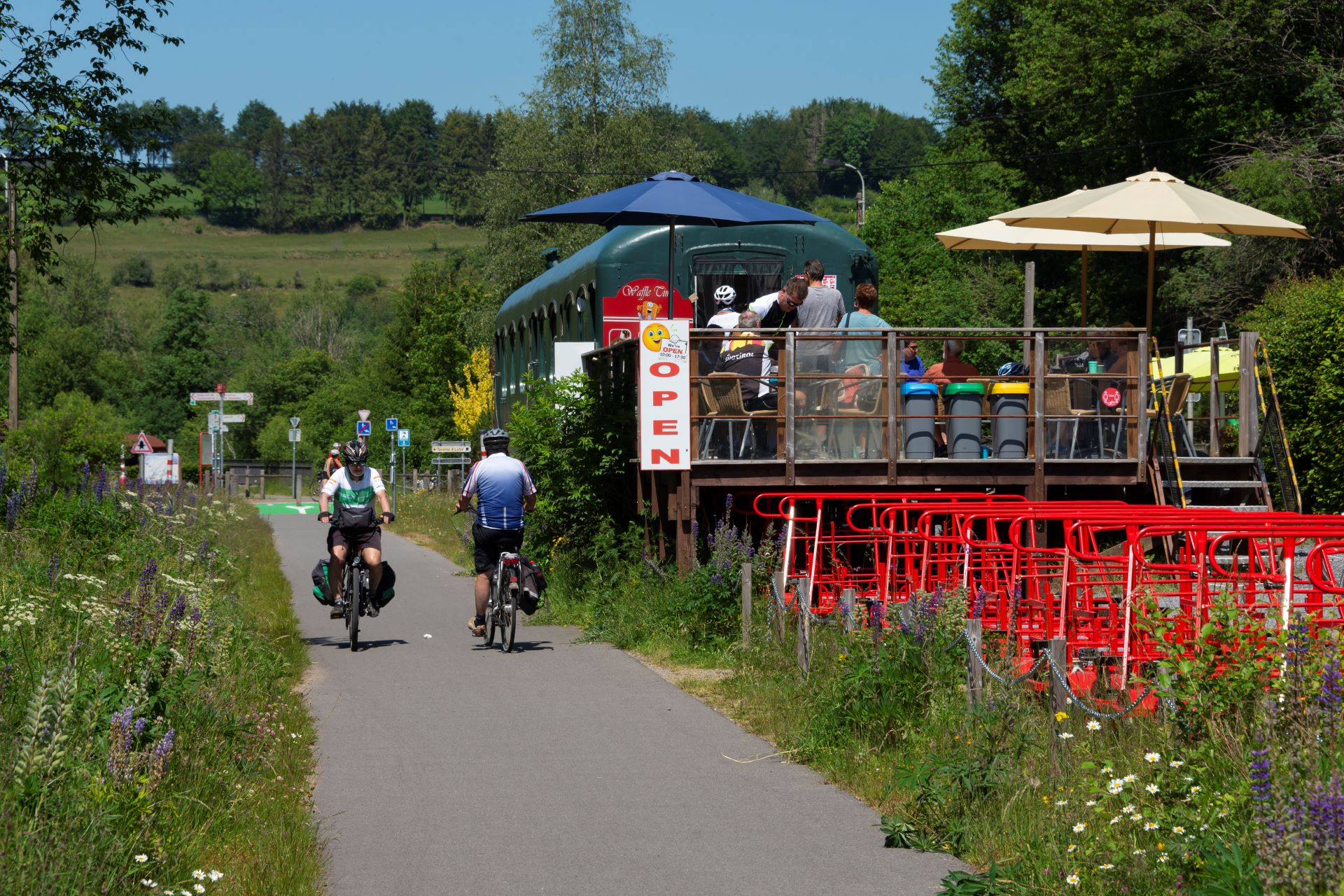Deux vététistes font du vélo à côté d'un restaurant sur la Vennbahn.