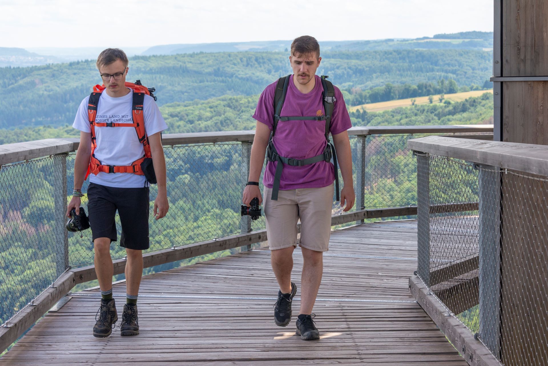 Deux membres du collectif de photographes Saarroamers sont photographiés sur une passerelle en bois qui sert de point d'observation sur la Sarre.