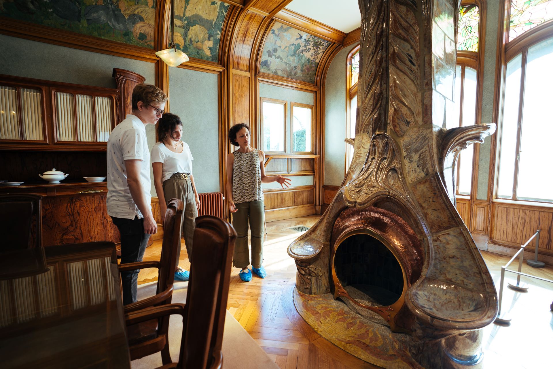 À l'intérieur du bâtiment, la guide montre à ses invités l'influence de la nature sur l'architecte. Une cheminée ancienne est construite dans des formes naturellement courbes.
