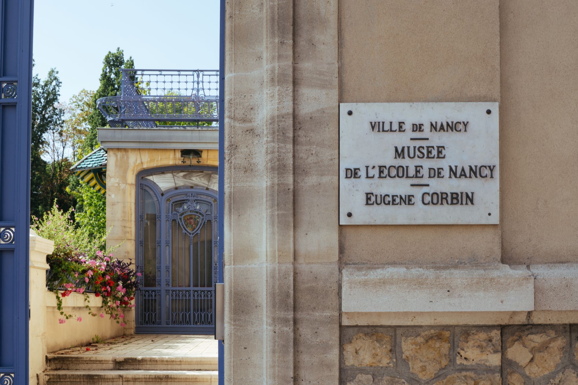 Un panneau sur une école historique de Nancy indique "Musée de l'école de Nancy" en français.