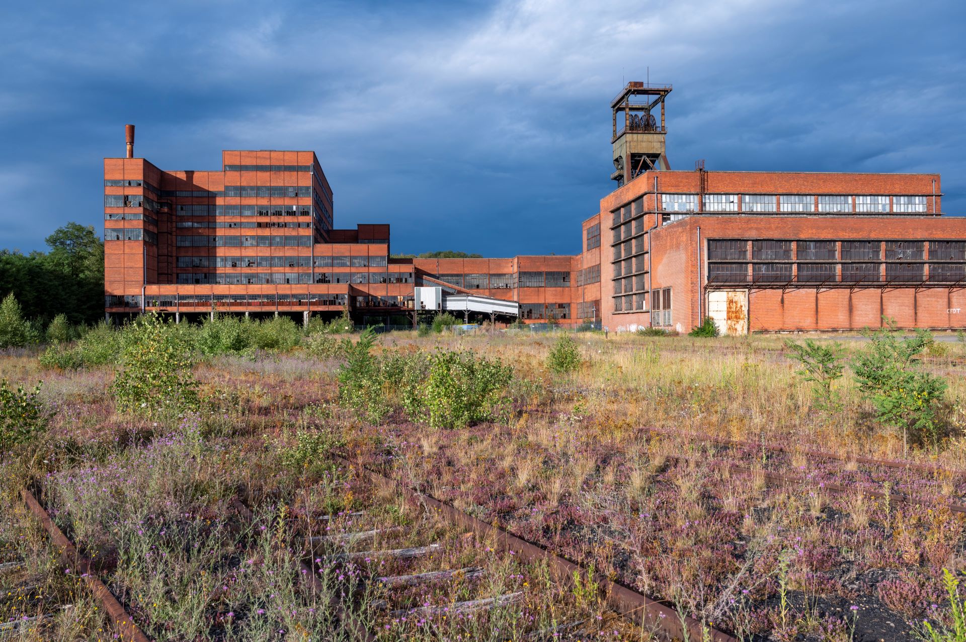 Lorsque le ciel s'assombrit et se couvre, les bâtiments de l'ancienne mine se distinguent par leur couleur rouge-brun.