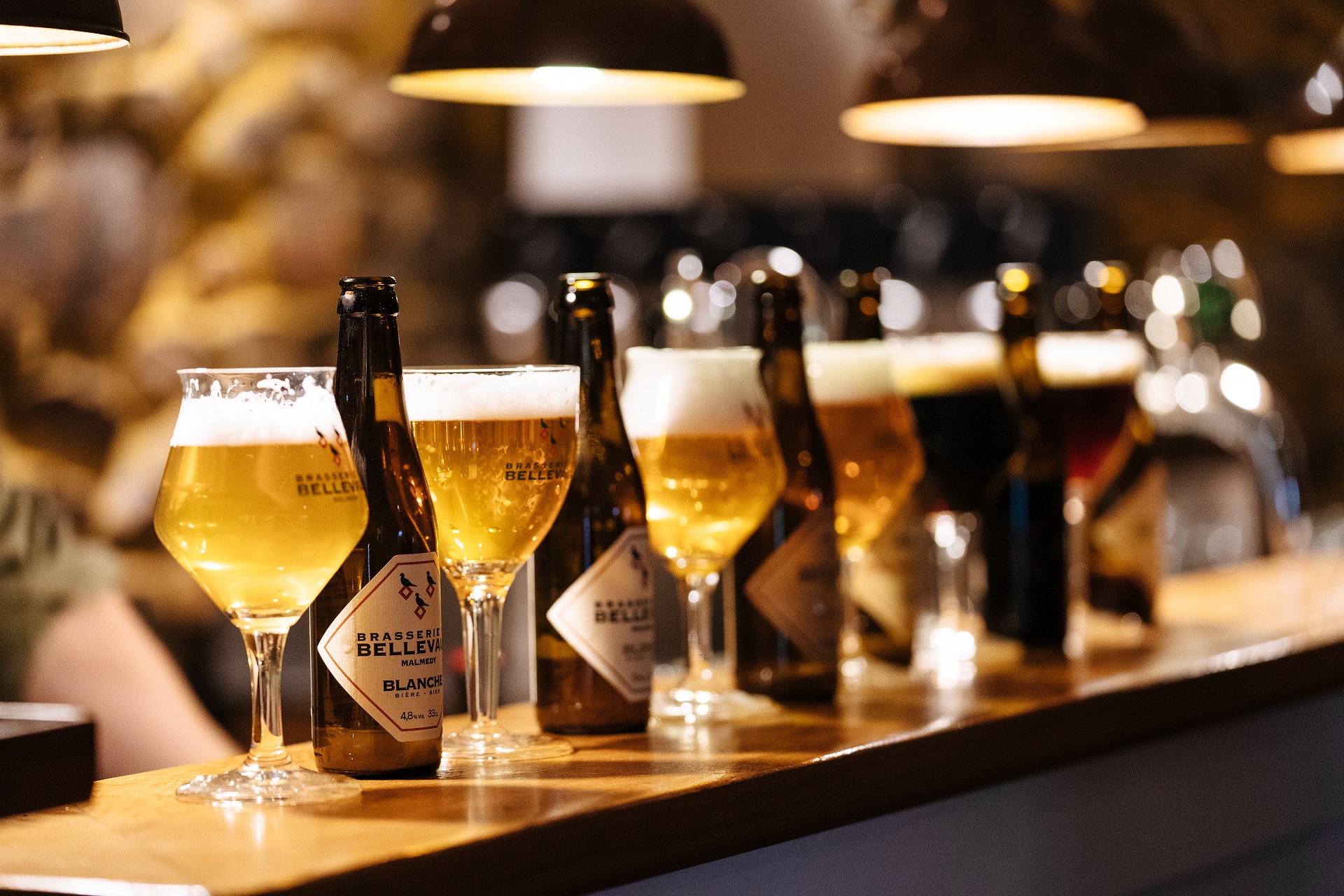 Sechs verschieden Biersorten, die auf einem Tresen aufgereiht stehen. Jedes Bier wurde in ein Glas ausgeschenkt.