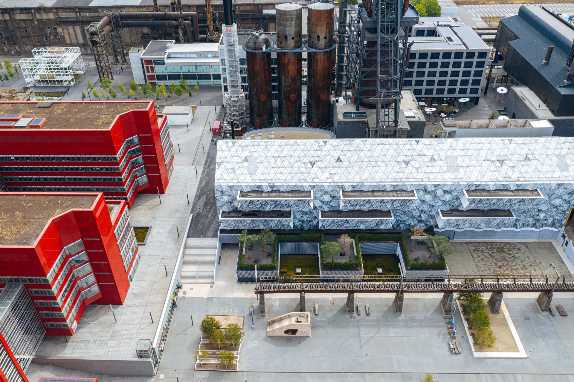 Hier sind die Universitätsgebäude rund um den Minett-Komplex gut sichtbar. Neue rot-weiße Universitätsgebäude im Vordergrund kontrastieren mit dem Industriebau im Hintergrund.