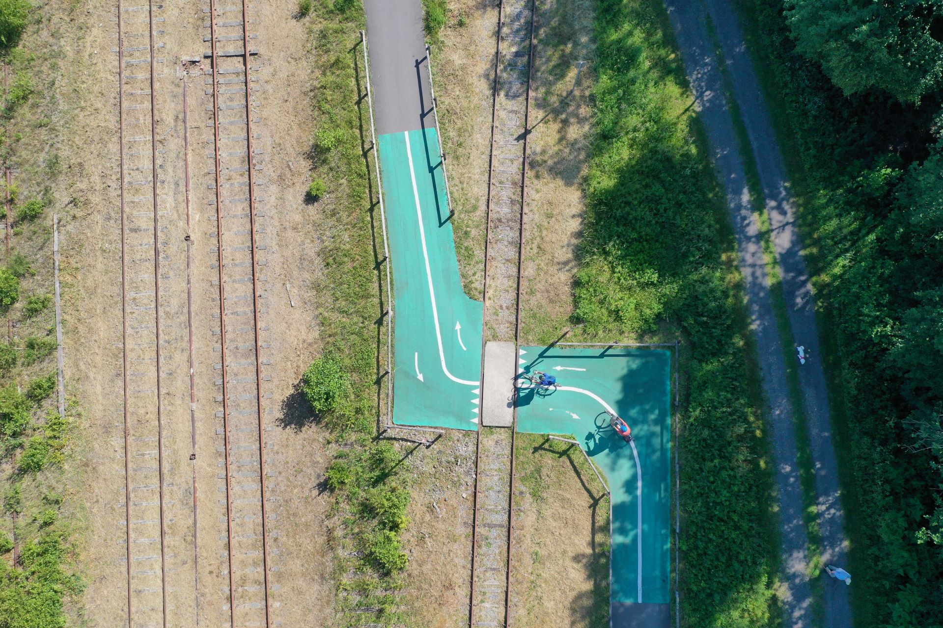 Ein Teil der Vennbahn ist aus der Luft sichtbar: Der türkisfarbene Radweg kreuzt die Bahngleise.
