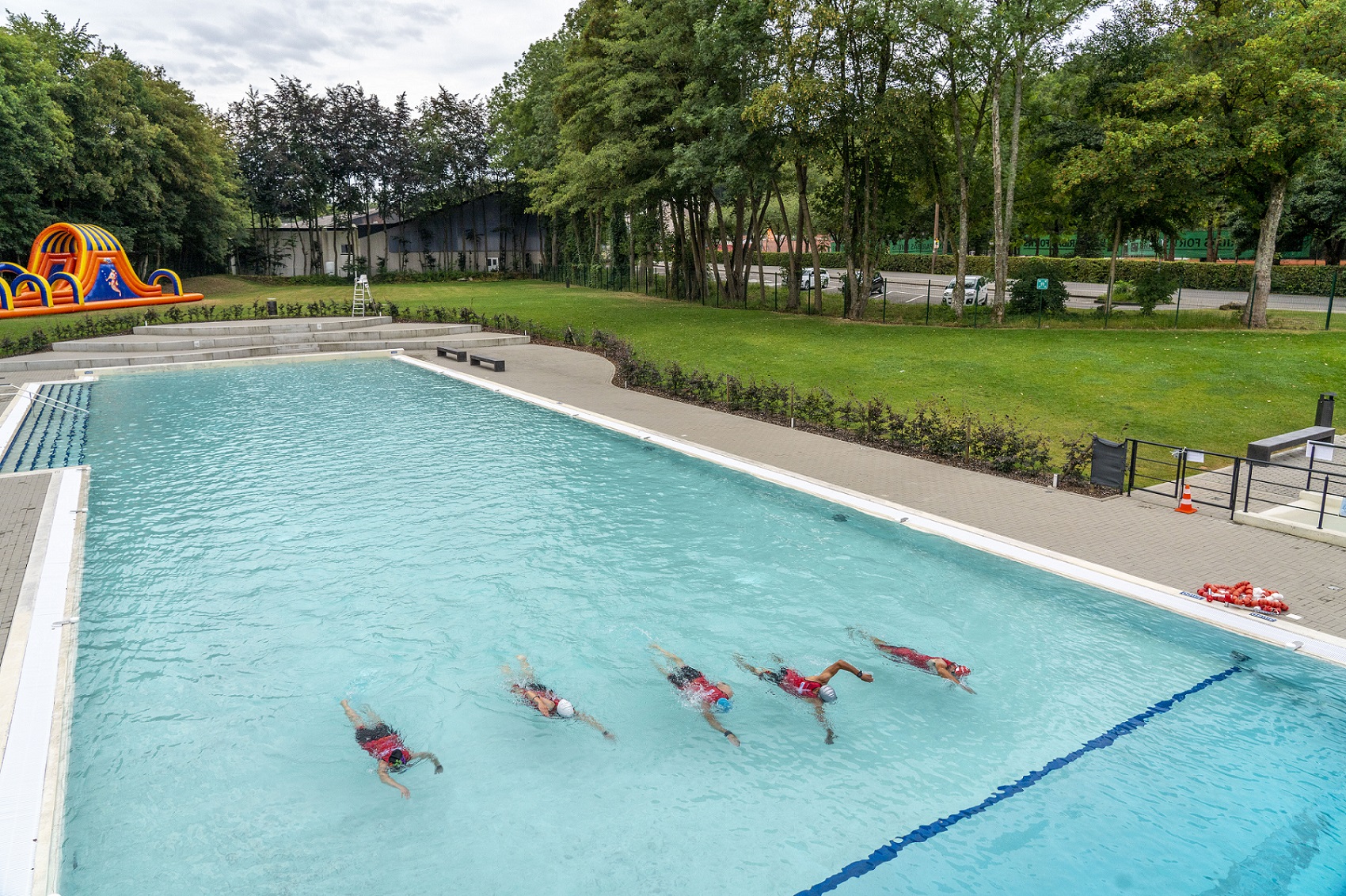 Fünf Triathleten beim Schwimmtraining im Becken von oben.