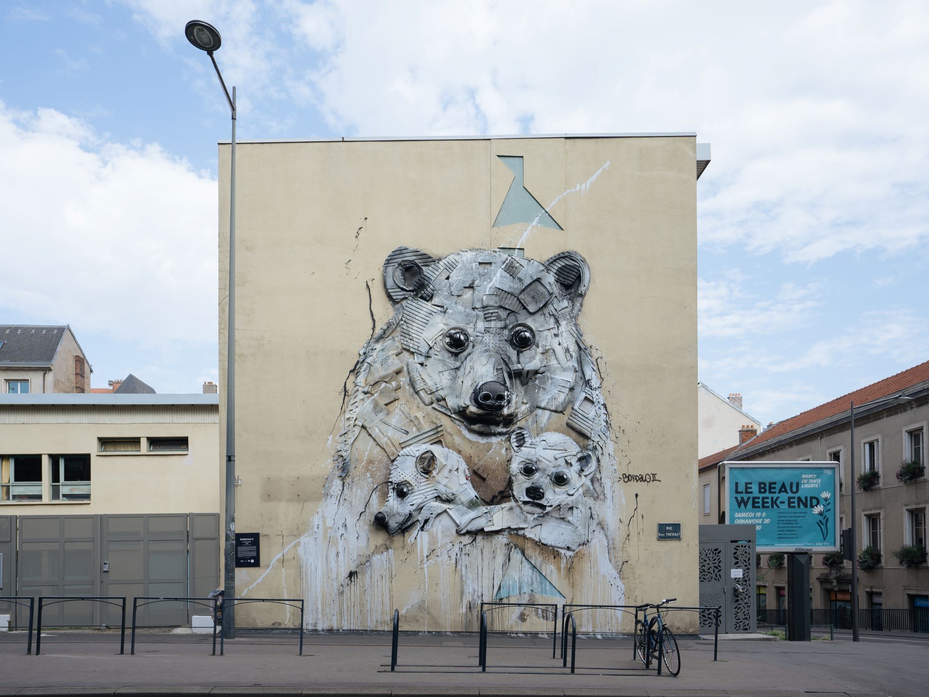 Ein berühmtes Straßenkunstwerk ist an der Seite eines Gebäudes zu sehen. Es zeigt drei Eisbären, eine Mutter mit ihren beiden Babys.