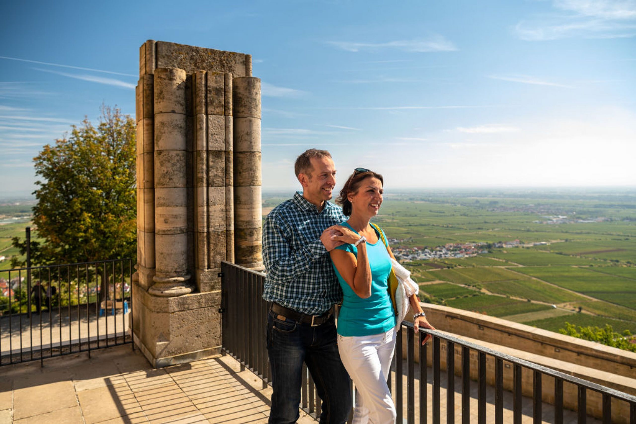 Ein Paar genießt die Aussicht vom Hambacher Schloss auf die Stadt Neustadt an der Weinstraße